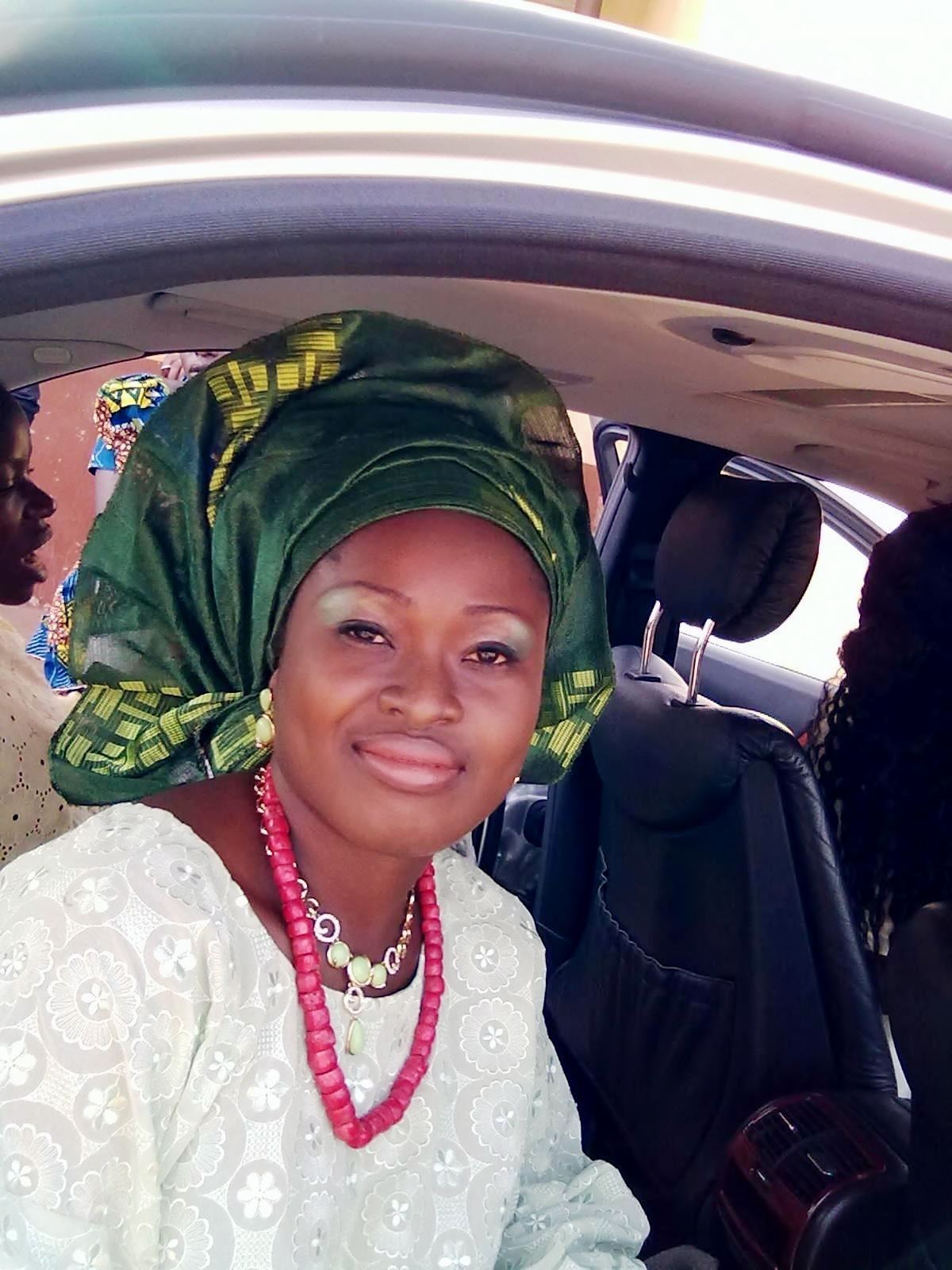 A Yoruba bride in a lace buba blouse and a tied gele headwrap