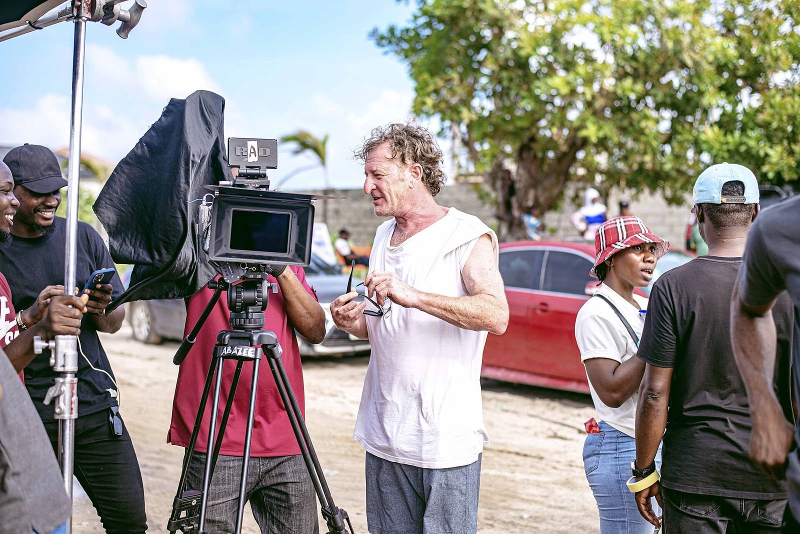 Film crew around a cinema camera on an outdoor Nollywood shoot