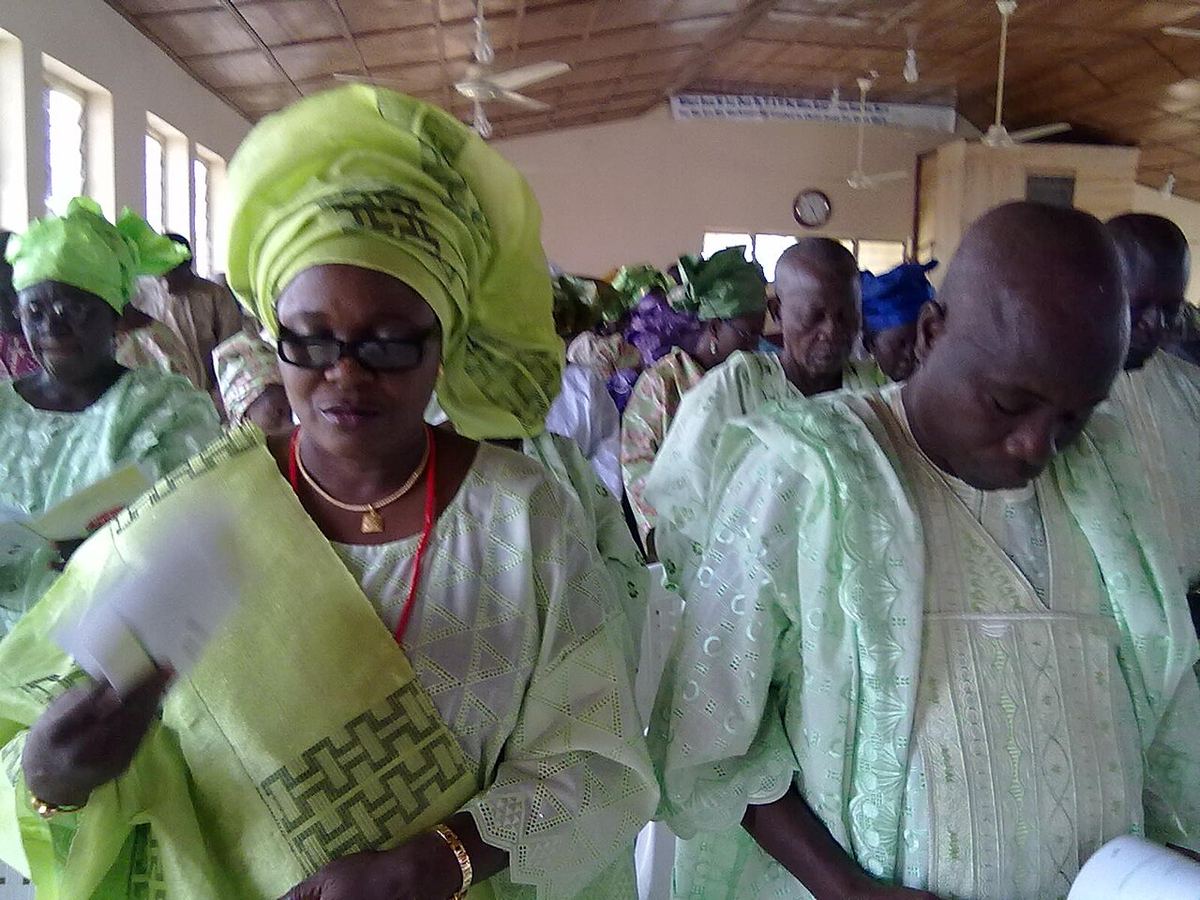 A Yoruba woman in a lace buba blouse and gele headwrap